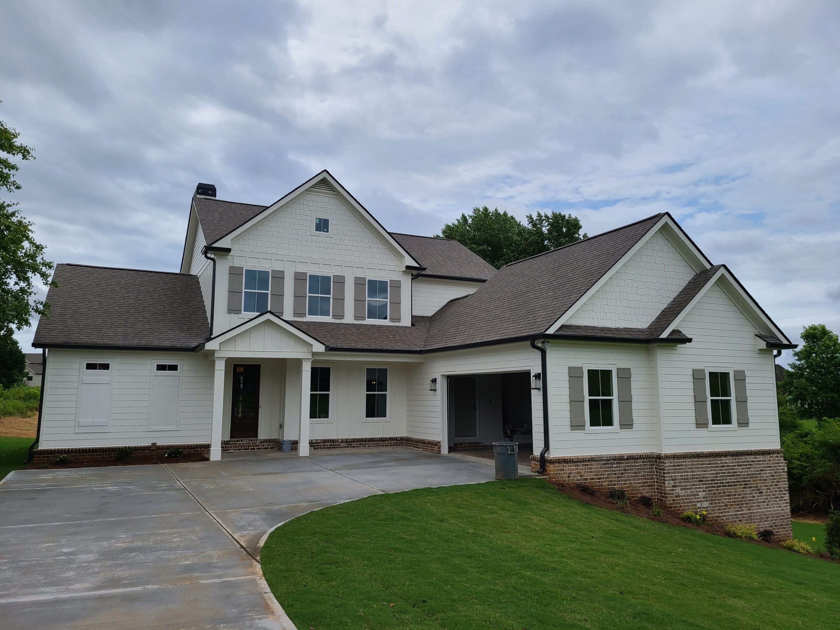 A modern two-story house with a large driveway and front lawn.