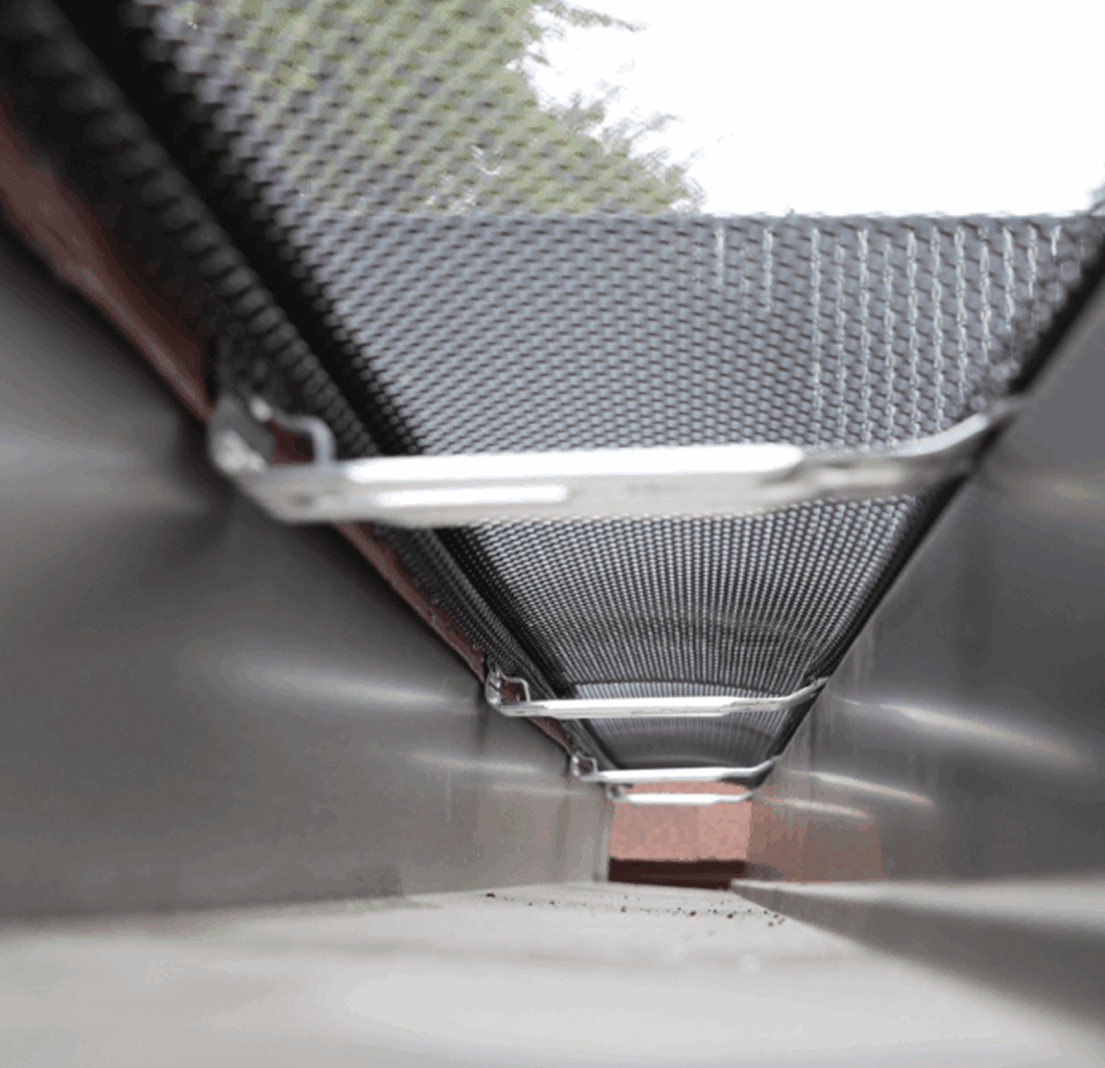 View inside a narrow metal duct with a light tube at the top.